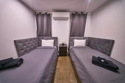two beds in a small room with gray beds at Modern 2 Bedroom Retreat in Downtown Manhattan in New York