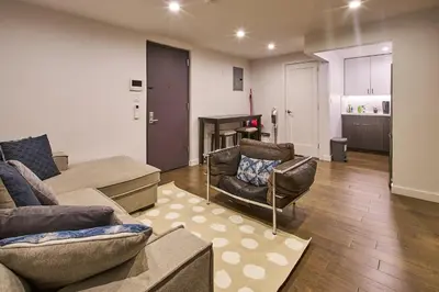 a living room with a couch and chairs and a kitchen at Modern 2 Bedroom Retreat in Downtown Manhattan in New York