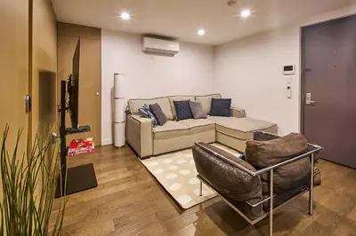 a living room with a couch and two chairs at Modern 2 Bedroom Retreat in Downtown Manhattan in New York