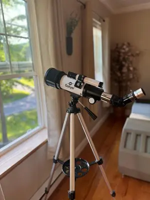 a telescope on a tripod next to a window at Charming, Restful Getaway in Bushkill