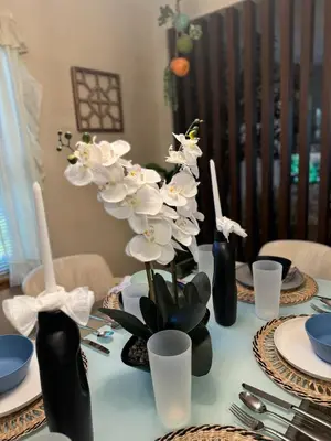 a table with black vases with white flowers on it at Charming, Restful Getaway in Bushkill