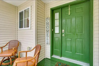 a green door on a house with two chairs at Charming, Restful Getaway in Bushkill