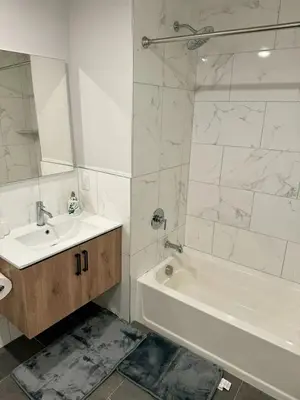a white bathroom with a sink and a tub and a mirror at Luxury Stay for NYC visit Jersey City 7 Min Walk NYC Train Station in Jersey City