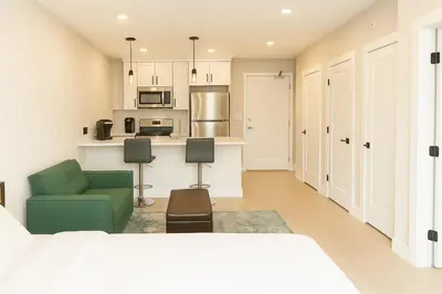 a living room with a bed and a kitchen at Luxury Stay for NYC visit Jersey City 7 Min Walk NYC Train Station in Jersey City