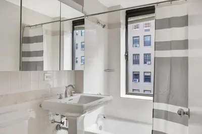 a white bathroom with a sink and a window at UWS 1BR w Elevator Gym nr Central Park NYC-686 in New York
