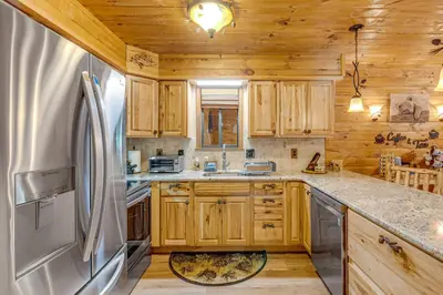 a kitchen with wooden cabinets and a refrigerator at Game Room and Hot Tub Pine Bear Pocono Lake Cabin in Pocono Lake