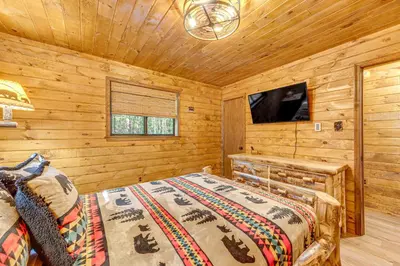 a bedroom with a bed in a log cabin at Game Room and Hot Tub Pine Bear Pocono Lake Cabin in Pocono Lake