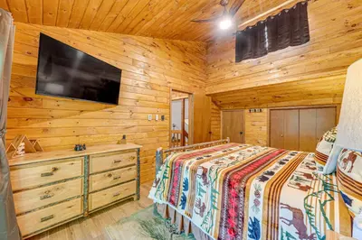 a bedroom with a bed and a flat screen tv at Game Room and Hot Tub Pine Bear Pocono Lake Cabin in Pocono Lake