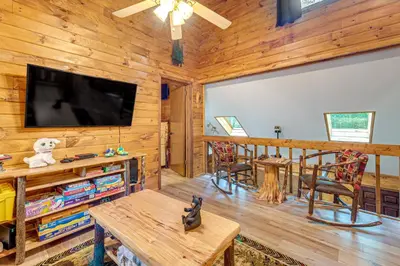 a living room with a flat screen tv in a log cabin at Game Room and Hot Tub Pine Bear Pocono Lake Cabin in Pocono Lake