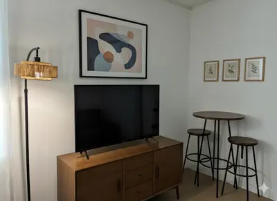a living room with a flat screen tv and two bar stools at Chill In The Village in New York