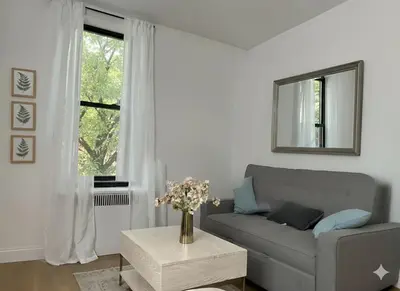 a living room with a couch and a window at Chill In The Village in New York