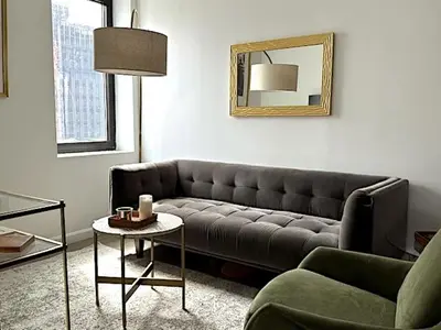 a living room with a couch and a mirror at Huge Modern 2 bedroom in Little Italy in New York