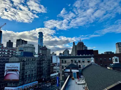 a view of a city with buildings and a blue sky at Luxury in Little Italy 2 Bedroom Private Balcony in New York