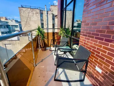 a balcony with two chairs and a brick wall at Luxury in Little Italy 2 Bedroom Private Balcony in New York