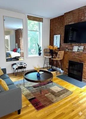 a living room with a couch and a fireplace at Beauty in the Heart of the Village in New York