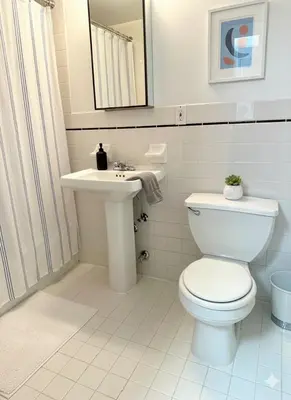a white bathroom with a toilet and a sink at Beauty in the Heart of the Village in New York