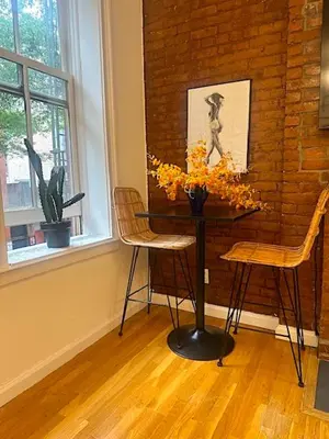 a table and two chairs in a room with a brick wall at Beauty in the Heart of the Village in New York