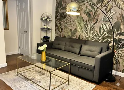 a living room with a couch and a glass table at West Village Lush Green in New York