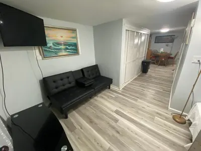 a living room with a black couch in a room at Oasis in New Jersey - 2BR NYC Access in West New York