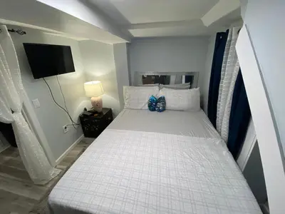 a bed in a small room with a television at Oasis in New Jersey - 2BR NYC Access in West New York