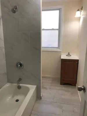 a bathroom with a bath tub and a sink at Spacious and private apartment with 3 bedrooms and 1 bathroom near Newark International Airport EWR and New York City, MetLife Stadium FIFA World Cup 20 minutes away in Newark