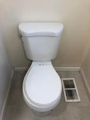 a white toilet in a bathroom with a vent at Spacious and private apartment with 3 bedrooms and 1 bathroom near Newark International Airport EWR and New York City, MetLife Stadium FIFA World Cup 20 minutes away in Newark