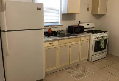 a kitchen with a white refrigerator and a sink at Private 3 bedroom and 1 bathroom house, direct NYC Manhattan train a 15 minute walk away, MetLife Stadium FIFA World Cup 35 minutes away in Perth Amboy