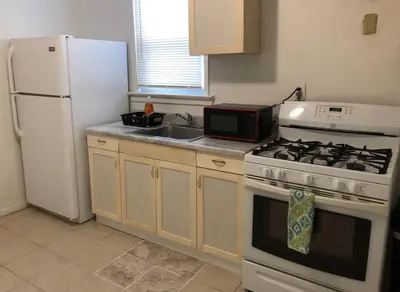 a kitchen with a white stove and a white refrigerator at Private 3 bedroom and 1 bathroom house, direct NYC Manhattan train a 15 minute walk away, MetLife Stadium FIFA World Cup 35 minutes away in Perth Amboy