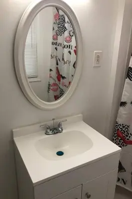 a bathroom with a white sink and a mirror at Private 3 bedroom and 1 bathroom house, direct NYC Manhattan train a 15 minute walk away, MetLife Stadium FIFA World Cup 35 minutes away in Perth Amboy