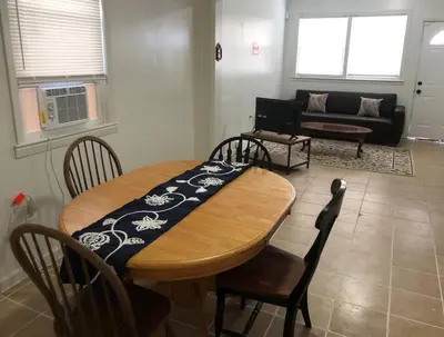 a living room with a table and chairs and a couch at Private 3 bedroom and 1 bathroom house, direct NYC Manhattan train a 15 minute walk away, MetLife Stadium FIFA World Cup 35 minutes away in Perth Amboy