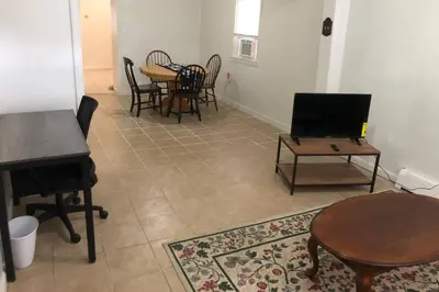 a living room with a table and chairs and a piano at Private 3 bedroom and 1 bathroom house, direct NYC Manhattan train a 15 minute walk away, MetLife Stadium FIFA World Cup 35 minutes away in Perth Amboy