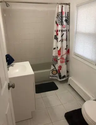 a bathroom with a sink and a shower curtain at Private 3 bedroom and 1 bathroom house, direct NYC Manhattan train a 15 minute walk away, MetLife Stadium FIFA World Cup 35 minutes away in Perth Amboy