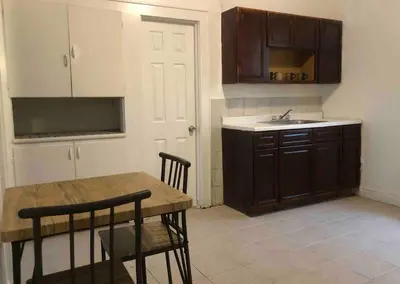 a kitchen with a wooden table and a sink at Spacious and bright 2-bedroom apartment with 1-bathroom and private street entrance, MetLife Stadium FIFA World Cup 25 minutes away in Paterson