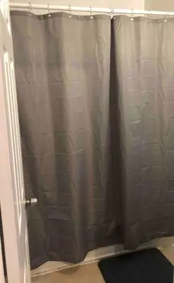 a shower with a gray shower curtain in a bathroom at Spacious and bright 2-bedroom apartment with 1-bathroom and private street entrance, MetLife Stadium FIFA World Cup 25 minutes away in Paterson
