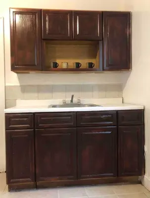 a kitchen with wooden cabinets and a sink at Spacious and bright 2-bedroom apartment with 1-bathroom and private street entrance, MetLife Stadium FIFA World Cup 25 minutes away in Paterson