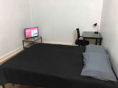 a bedroom with a bed and a desk with a computer at Spacious 2-bedroom apartment with 1-bathroom and private street entrance, MetLife Stadium FIFA World Cup 25 minutes away in Paterson