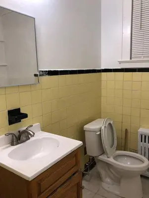 a bathroom with a sink and a toilet and a mirror at Spacious 2-bedroom apartment with 1-bathroom and private street entrance, MetLife Stadium FIFA World Cup 25 minutes away in Paterson