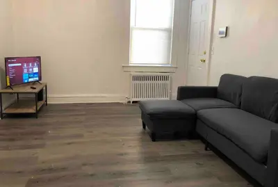 a living room with a couch and a tv at Spacious 2-bedroom apartment with 1-bathroom and private street entrance, MetLife Stadium FIFA World Cup 25 minutes away in Paterson