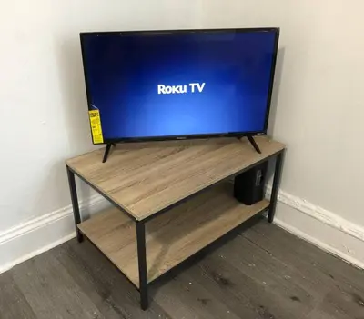 a tv sitting on top of a wooden table at Spacious 2-bedroom apartment with 1-bathroom and private street entrance, MetLife Stadium FIFA World Cup 25 minutes away in Paterson