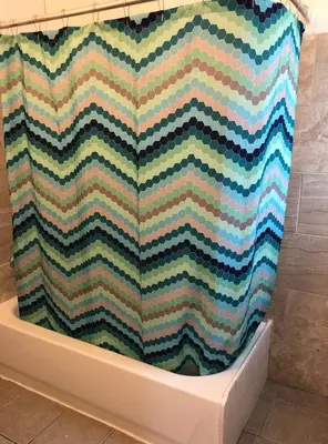 a bath tub with a checkered shower curtain in a bathroom at Spacious 2-bedroom apartment with 1-bathroom and private street entrance, MetLife Stadium FIFA World Cup 25 minutes away in Paterson