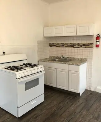 a kitchen with a white stove and a sink at Spacious 2-bedroom apartment with 1-bathroom and private street entrance, MetLife Stadium FIFA World Cup 25 minutes away in Paterson