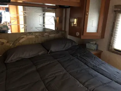 a large bed in a room with a window at Private 1-bedroom RV, direct bus to NYC Manhattan only 2 blocks away, MetLife Stadium FIFA World Cup 25 minutes away in Linden