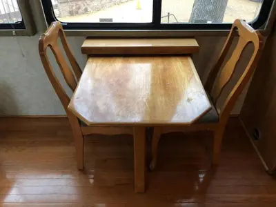 a wooden table and two chairs in front of a window at Private 1-bedroom RV, direct bus to NYC Manhattan only 2 blocks away, MetLife Stadium FIFA World Cup 25 minutes away in Linden
