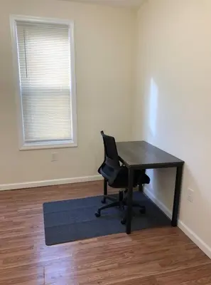 a desk and a chair in a room with a window at Large and private 3 bedroom and 1 bathroom apartment near Newark International Airport EWR and New York City, MetLife Stadium FIFA World Cup 20 minutes away in Newark