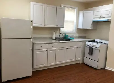 a kitchen with white cabinets and a white refrigerator at Large and private 3 bedroom and 1 bathroom apartment near Newark International Airport EWR and New York City, MetLife Stadium FIFA World Cup 20 minutes away in Newark