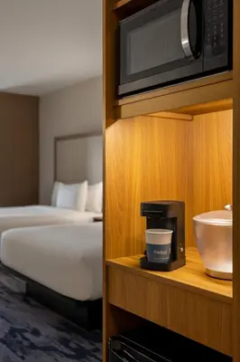 a hotel room with a bed and a microwave at Fairfield by Marriott Inn & Suites Bethlehem PA in Bethlehem