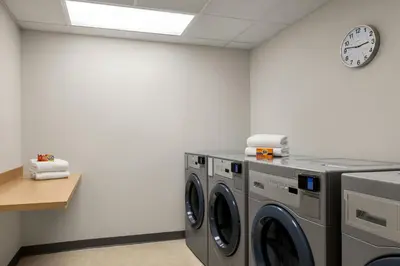 a laundry room with two washing machines and a clock at Fairfield by Marriott Inn & Suites Bethlehem PA in Bethlehem