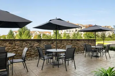 a patio with tables and chairs with umbrellas at Fairfield by Marriott Inn & Suites Bethlehem PA in Bethlehem