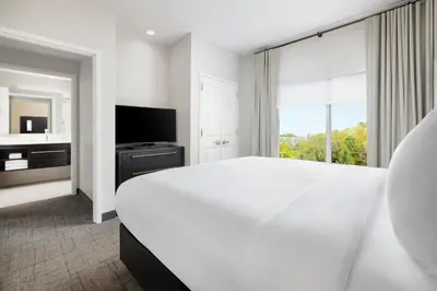 a white bedroom with a large bed and a large window at Residence Inn by Marriott King of Prussia in King of Prussia