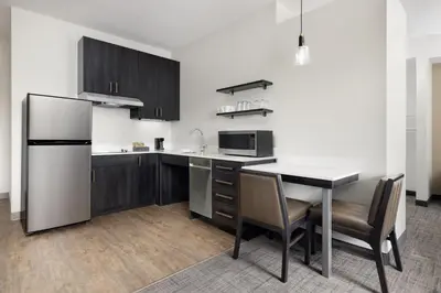 a kitchen with a refrigerator and a table and chairs at Residence Inn by Marriott King of Prussia in King of Prussia